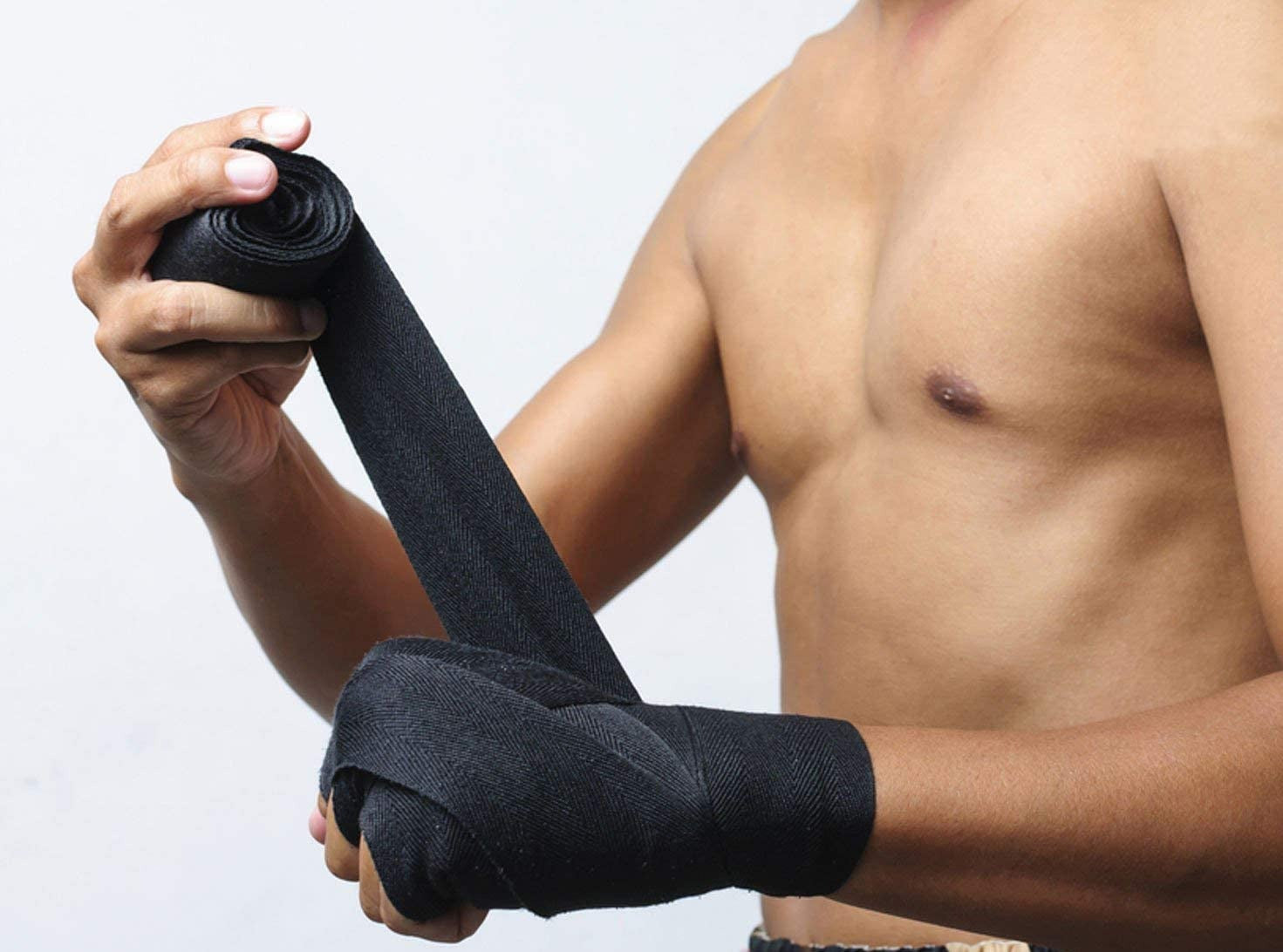 Person wrapping black boxing hand wraps around their wrist